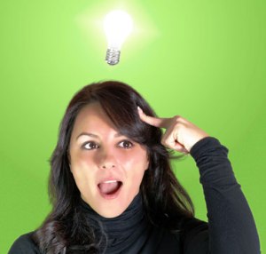 A woman pointing to her head while a light bulb lights up above her head signifying she received insight in her mind.